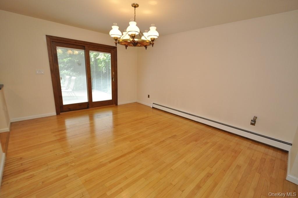 Photo Visually Staged.  The Dining Room has hardwood floors, opens to both the Kitchen and Living room and has sliding glass doors to the back patio a