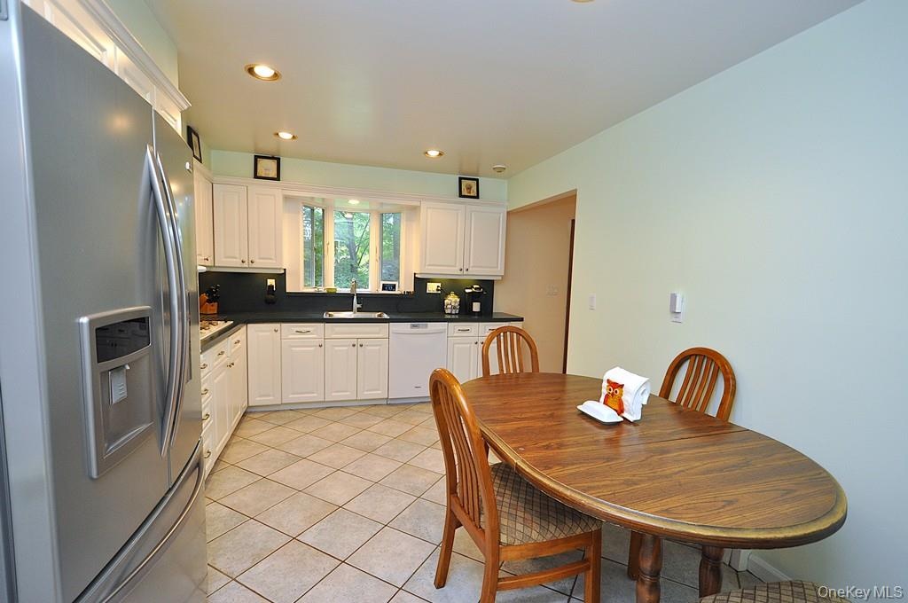 Updated Eat-in-kitchen with granite counters, Stainless Steel French Door refrigerator, wall oven, stove top, and microwave.  There is a window over t