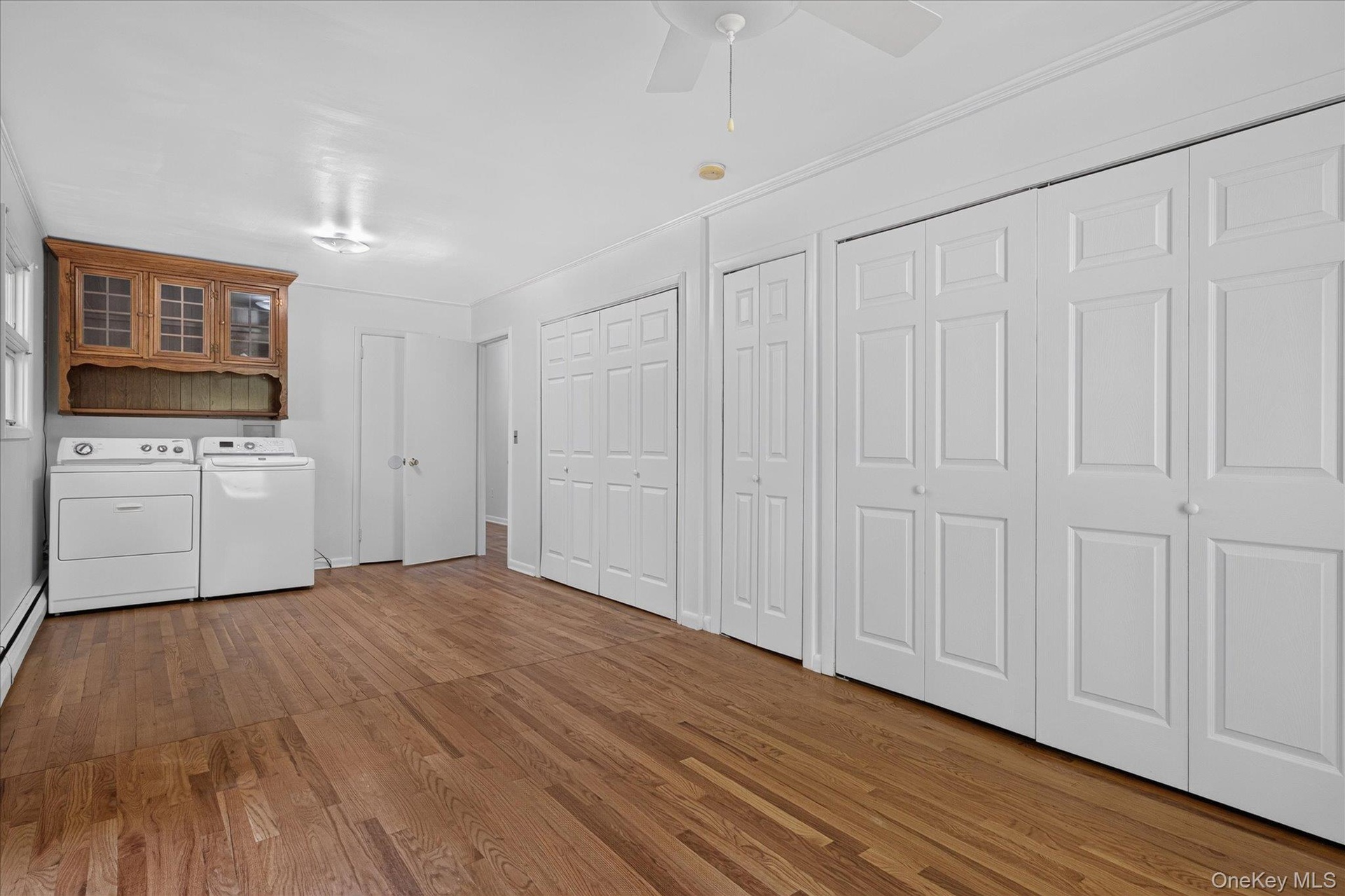 Bedroom with Laundry & a Wall of Closets