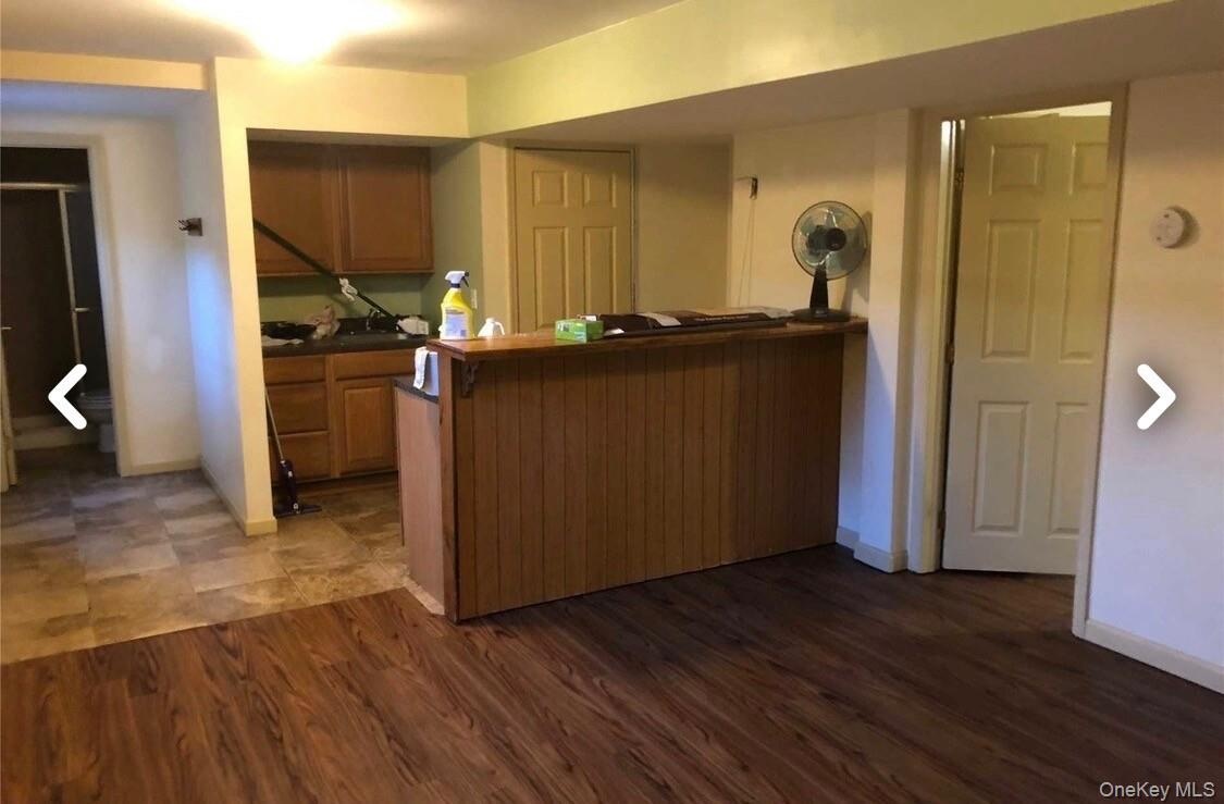 Apartment. Wood-finish flooring, built-in bar, and a kitchen area with wood cabinetry