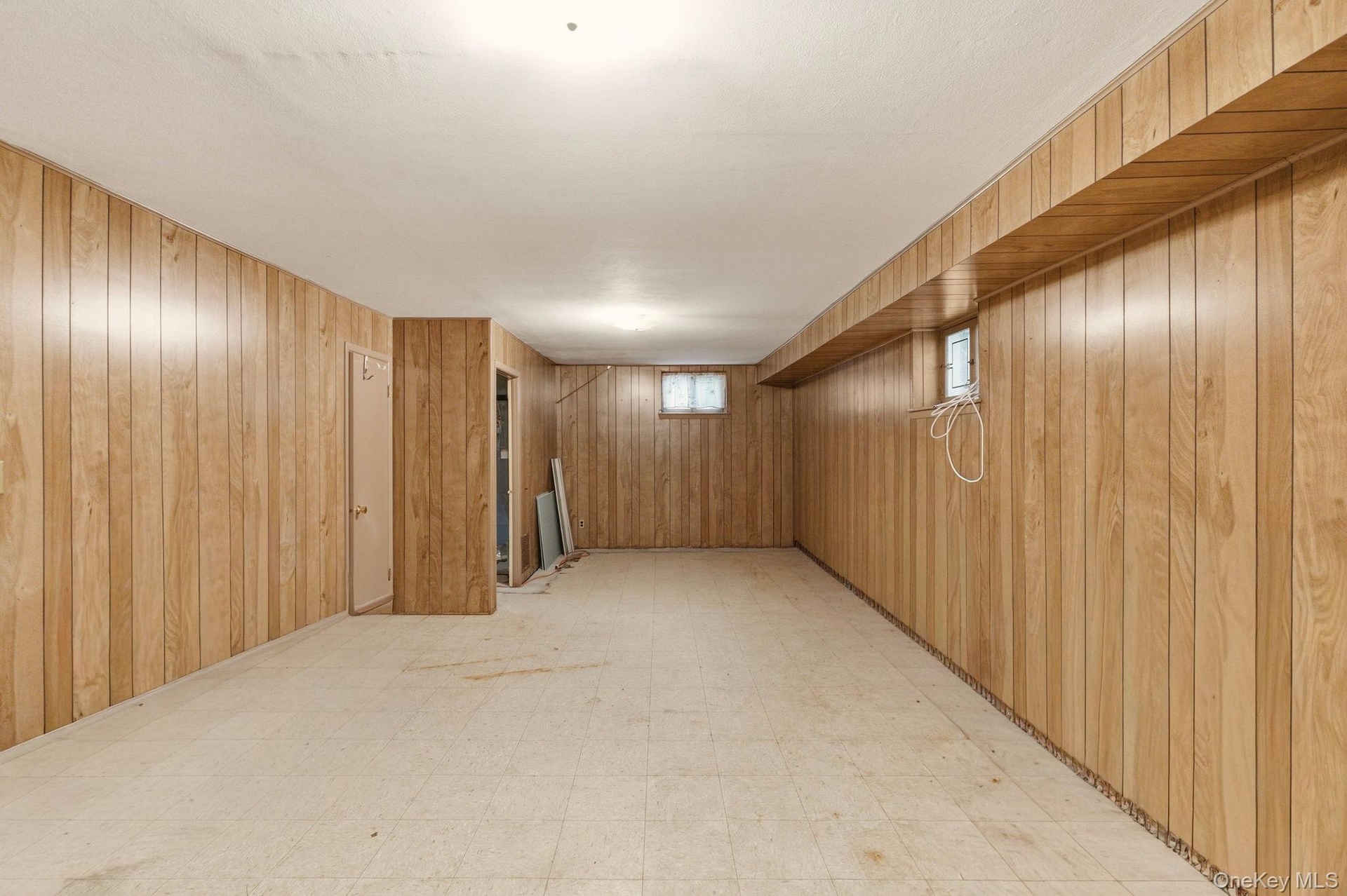 Wood-finish wall paneling, recessed lighting, and vinyl flooring