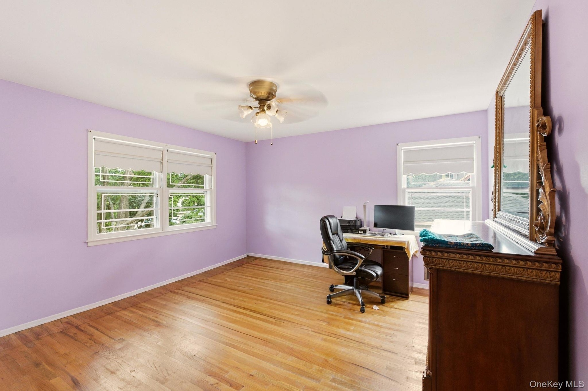 Hardwood flooring, multiple windows, ceiling fan, and ample wall space