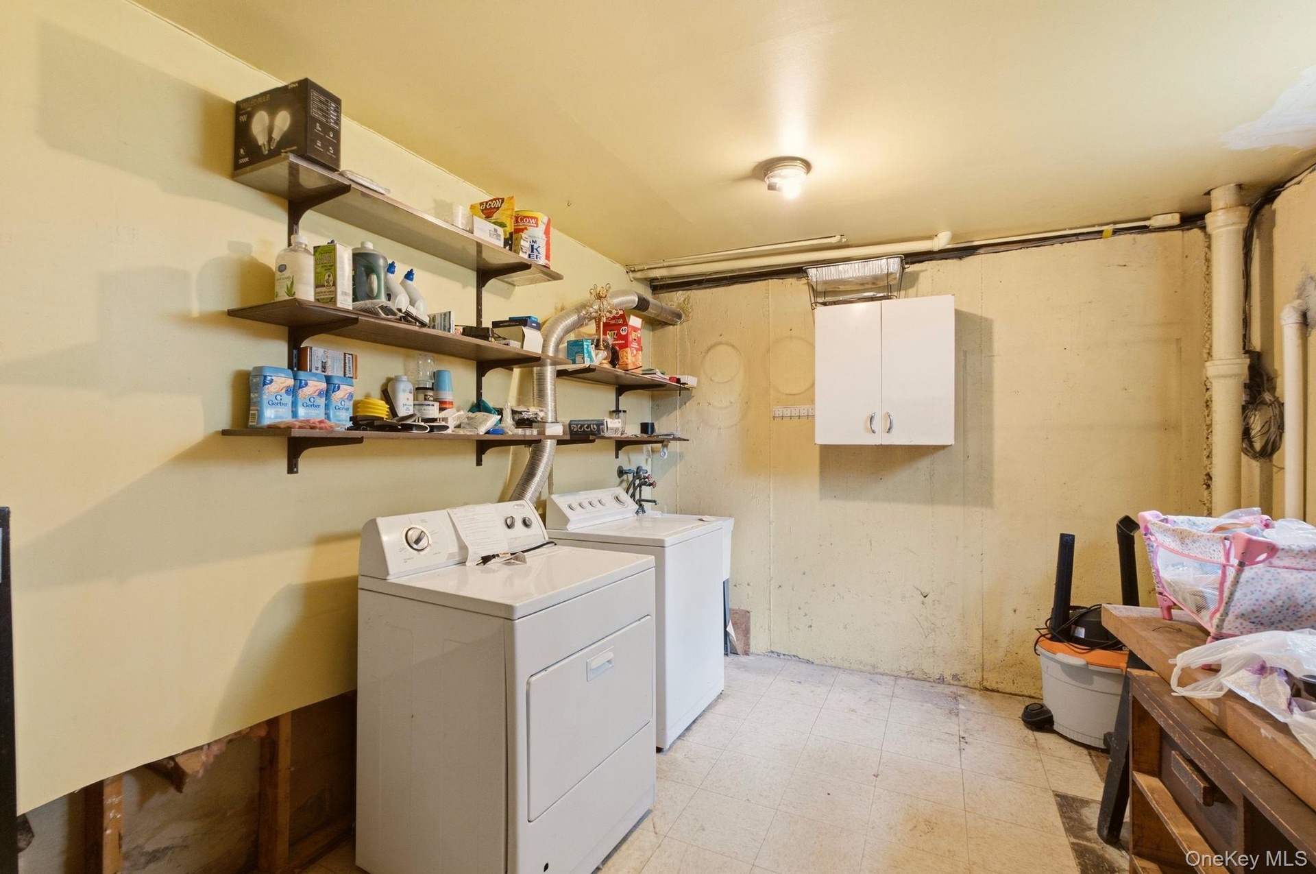 Wall-mounted shelving, built-in wall cabinet, and overhead lighting