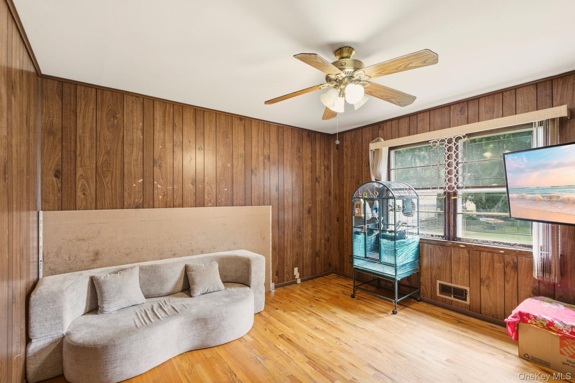 Wood-paneled walls and a ceiling fan with integrated lighting