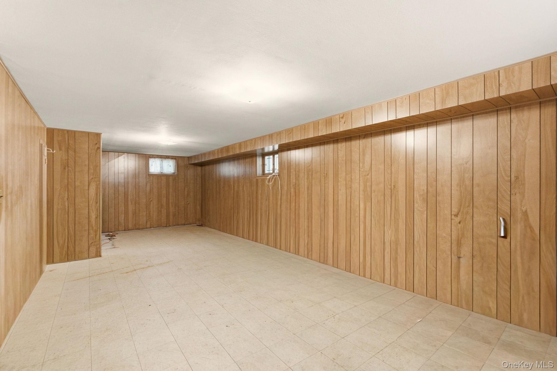 Wood paneling throughout, multiple windows for natural light, and tile flooring