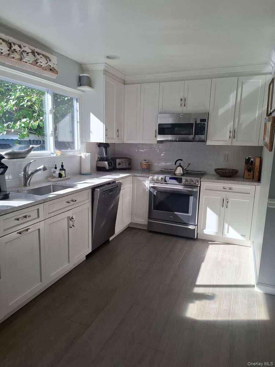 Stainless steel appliances and eat in area and access to living room