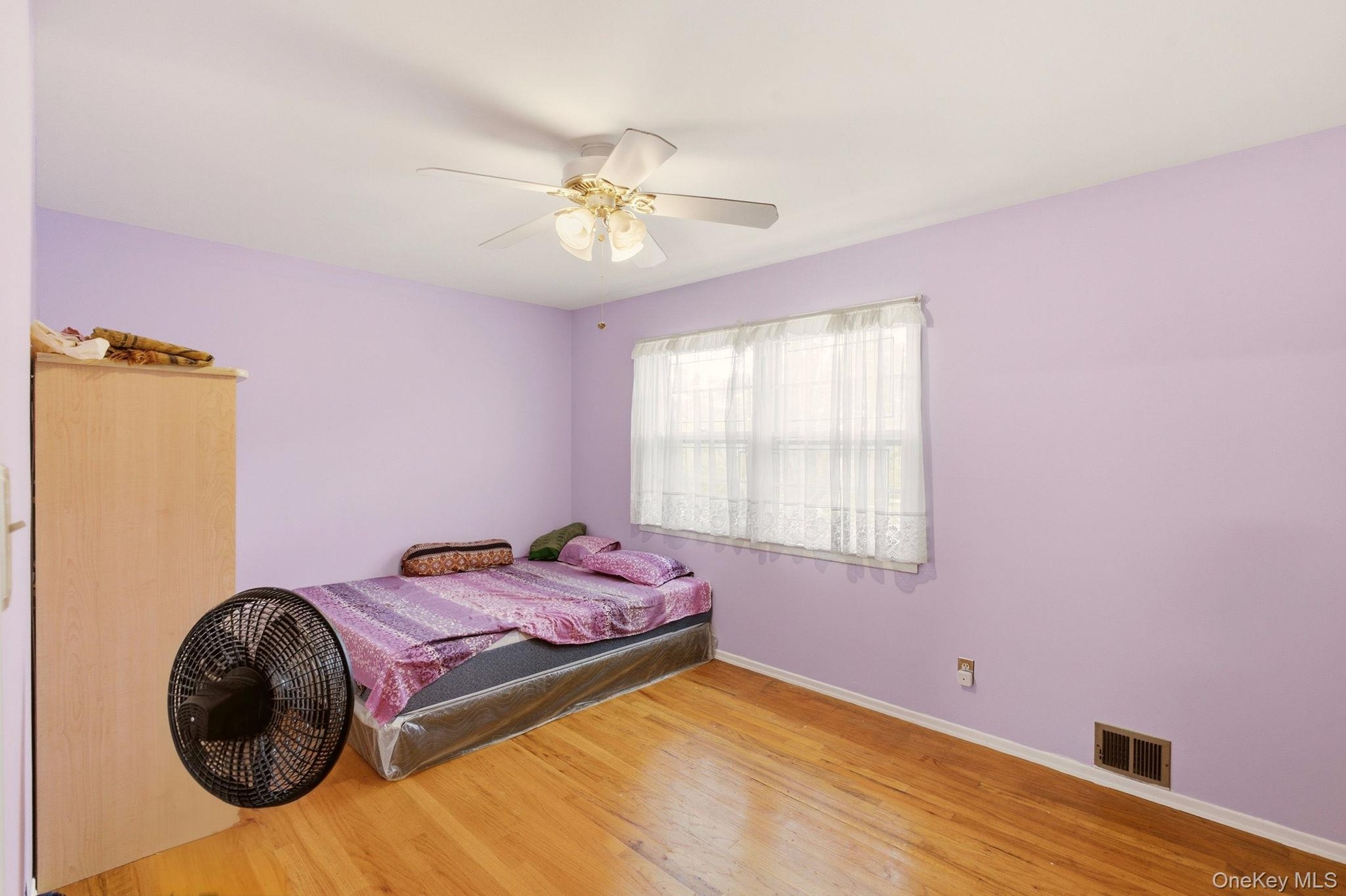 Wood-finish flooring, ceiling fan, and window with blinds