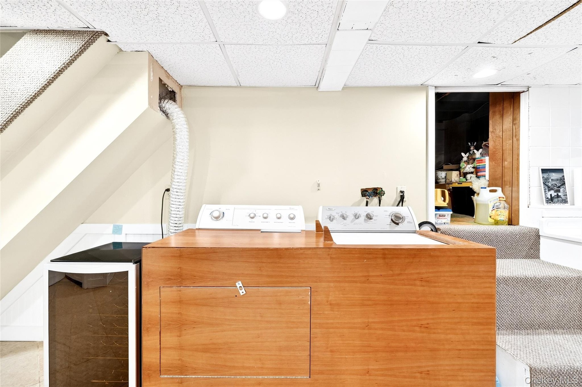 Washroom featuring a paneled ceiling and washing machine and dryer