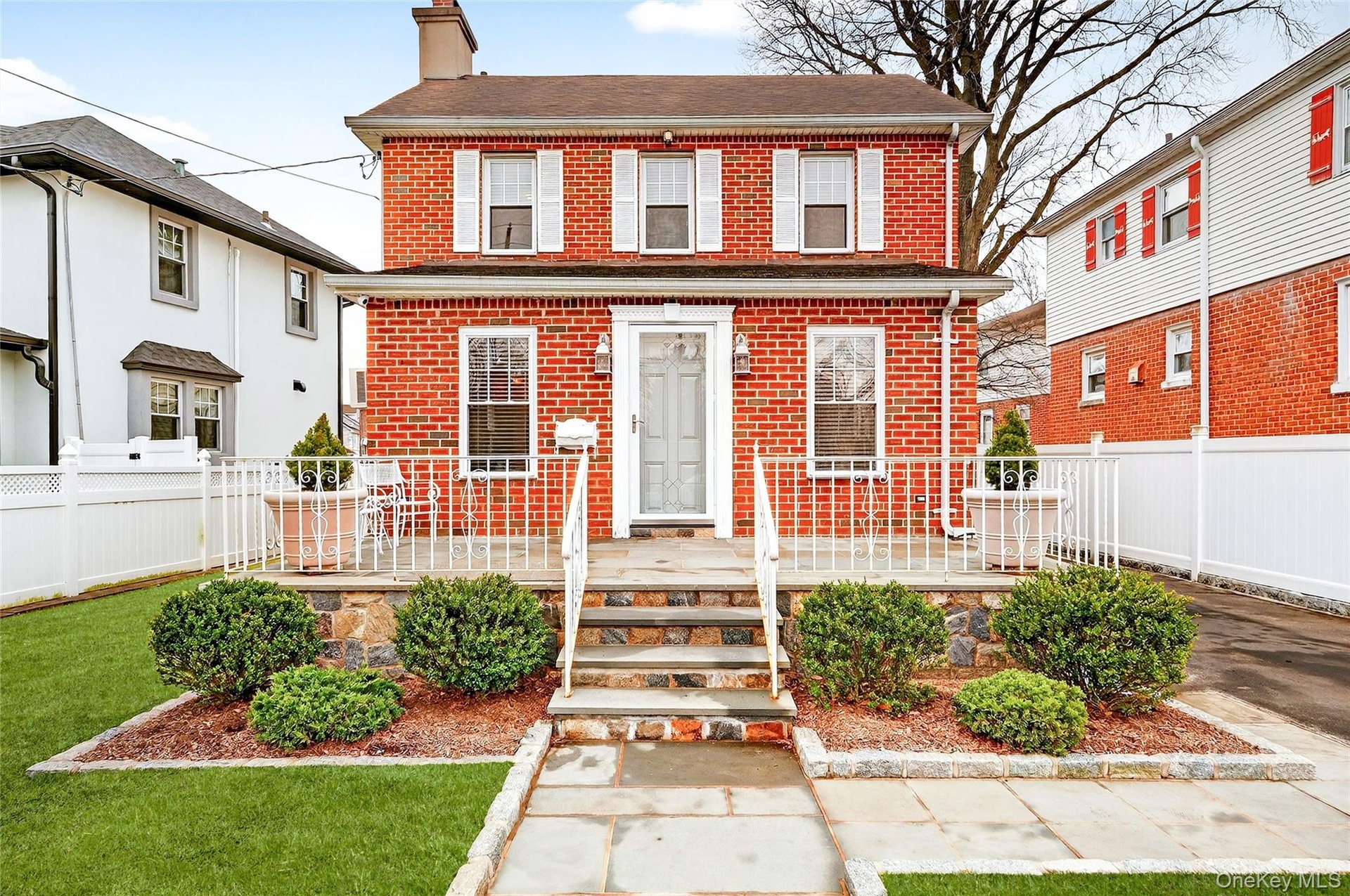 View of front of home with brick siding and a chimney