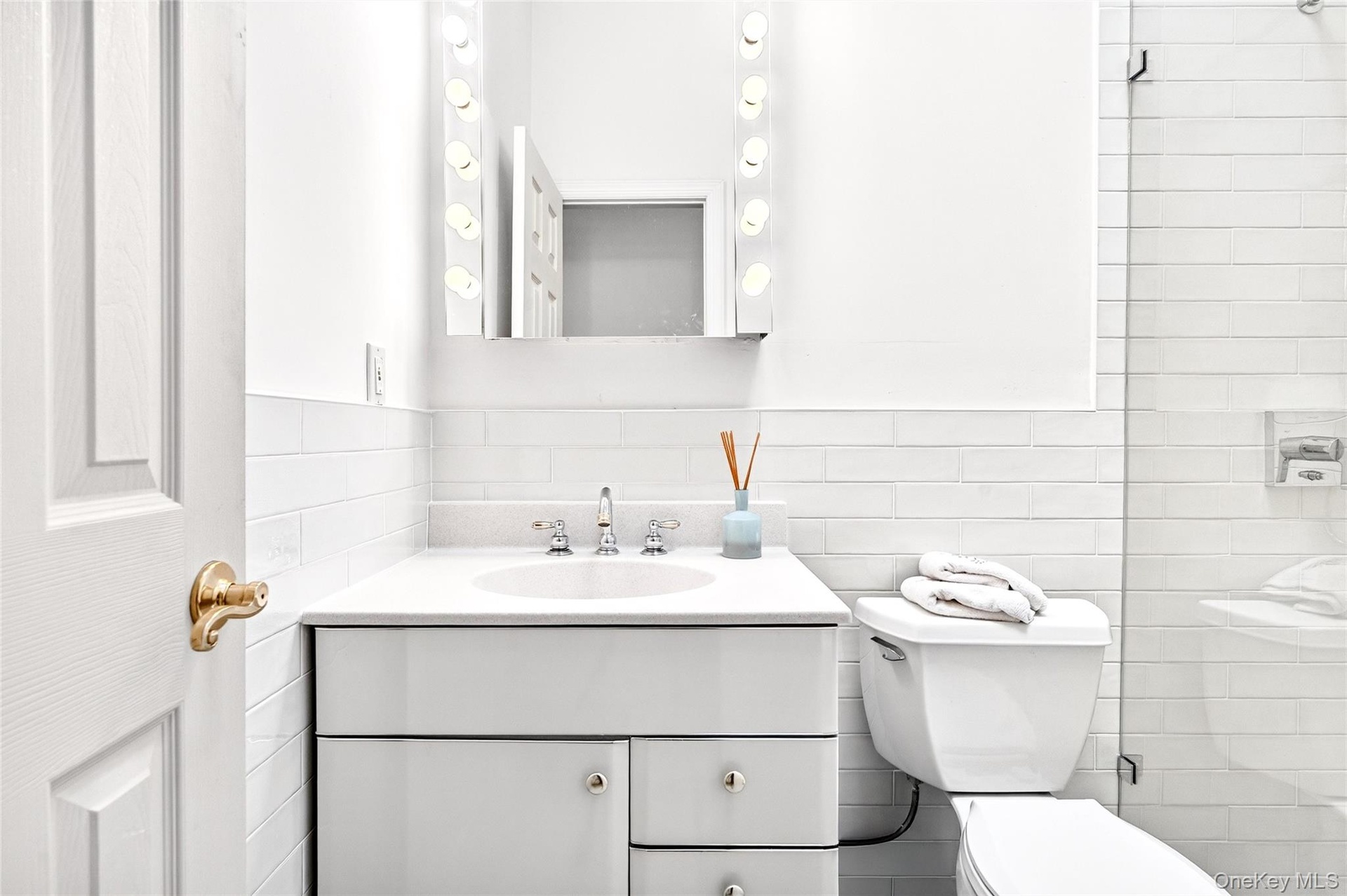 Full bath featuring vanity, tile walls, a tile shower, and decorative backsplash