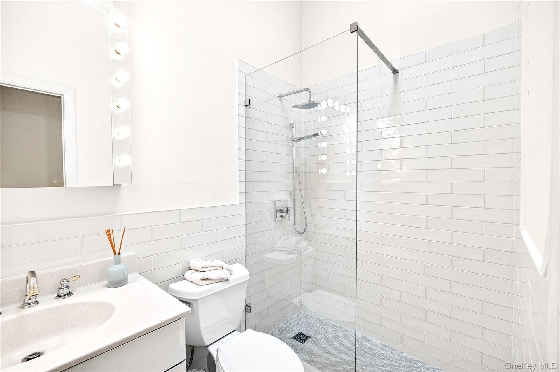 Bathroom with walk in shower, vanity, decorative backsplash, and tile walls