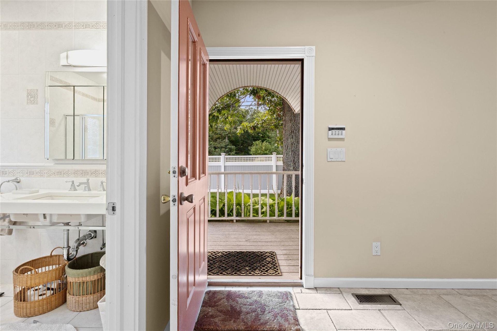 Tiled flooring, light-colored walls, white railing, and a wood deck