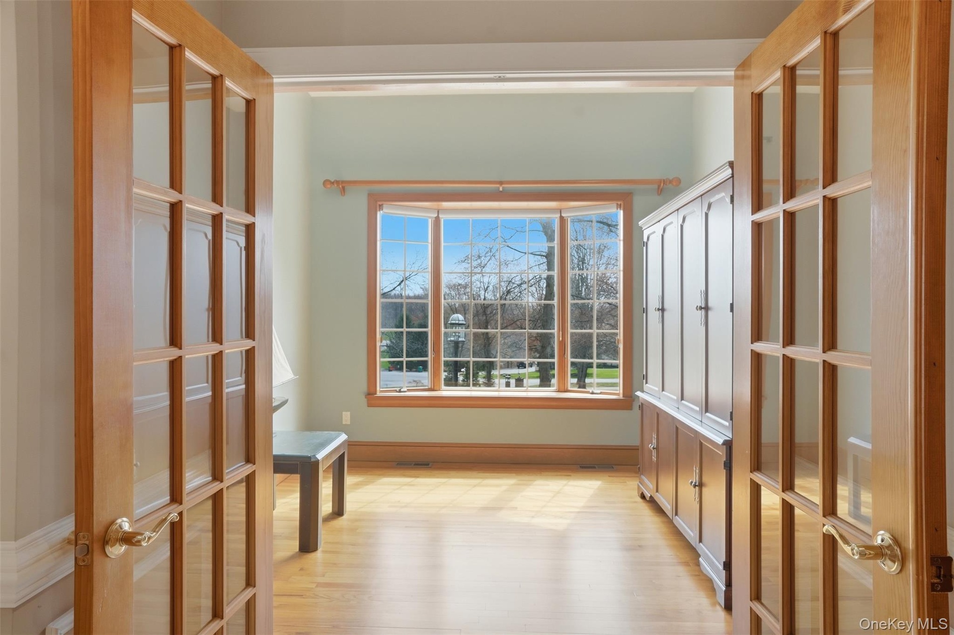 This room features hardwood floors and a large bay window providing abundant natural light
