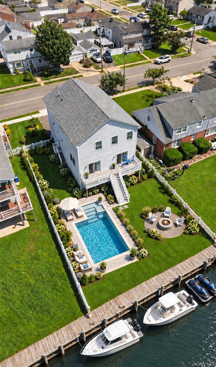Digitally staged yard featuring pool and fire pit .