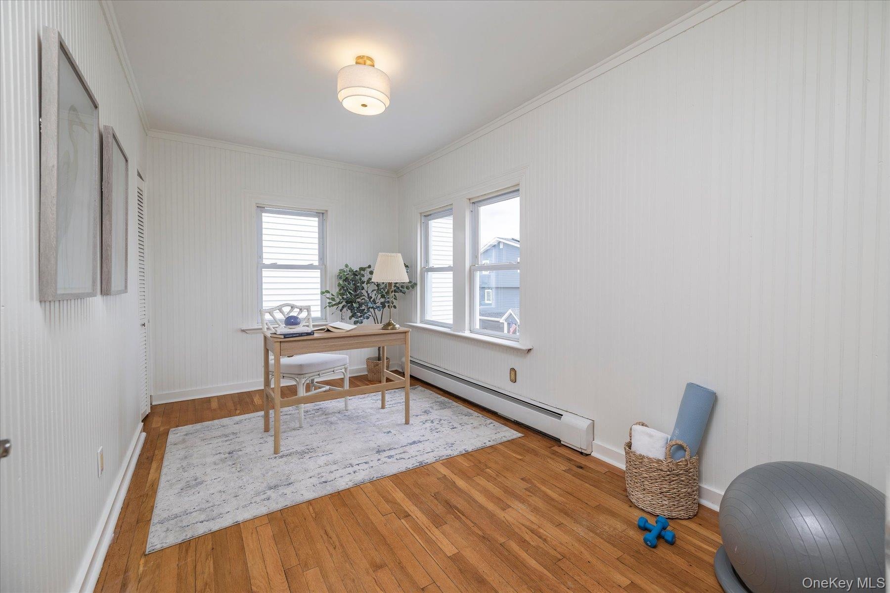 Bedroom with hardwood floors, currently used as an office.