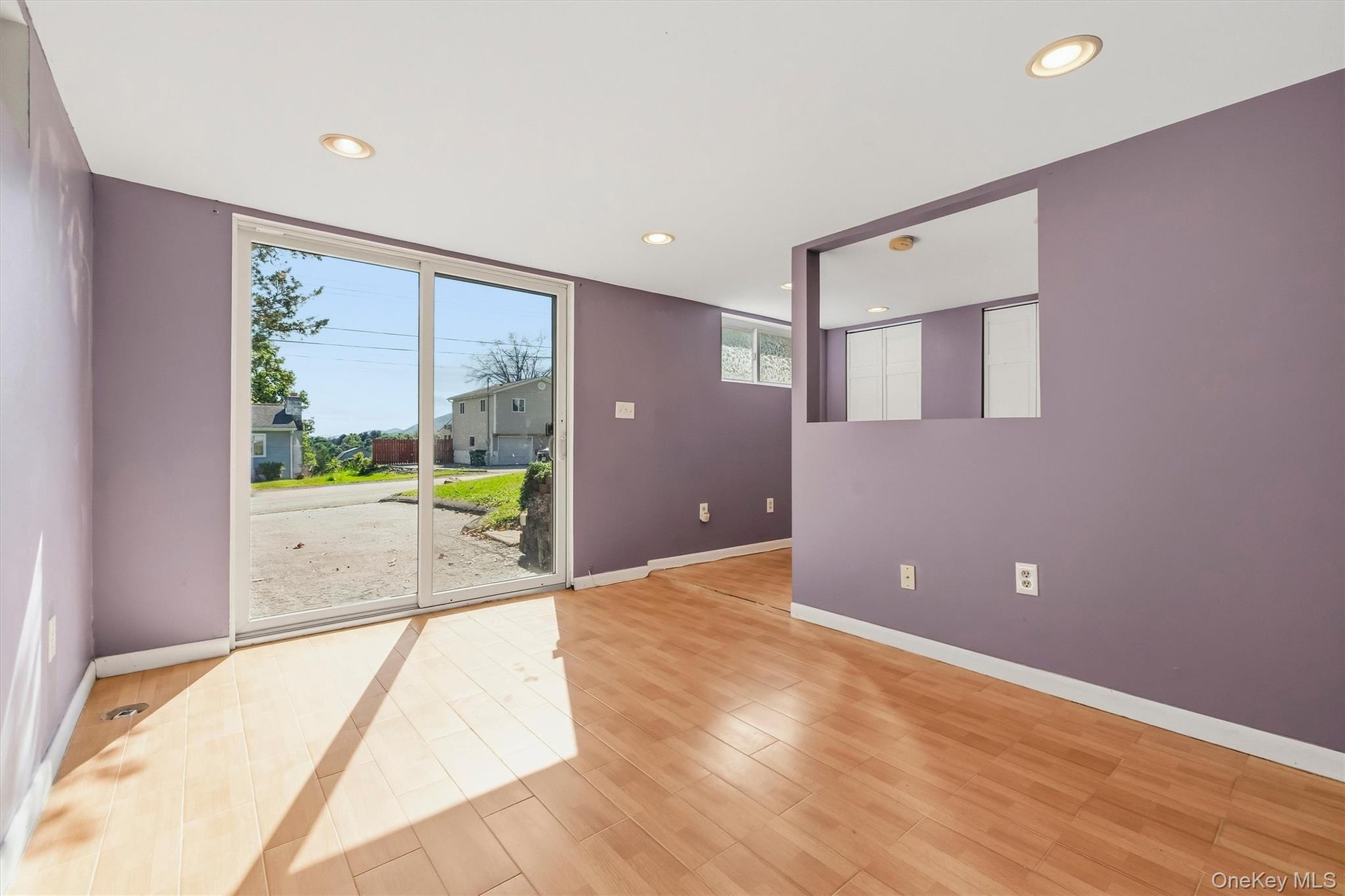 Large recreation room on lower level with sliding glass door to the front of the home.