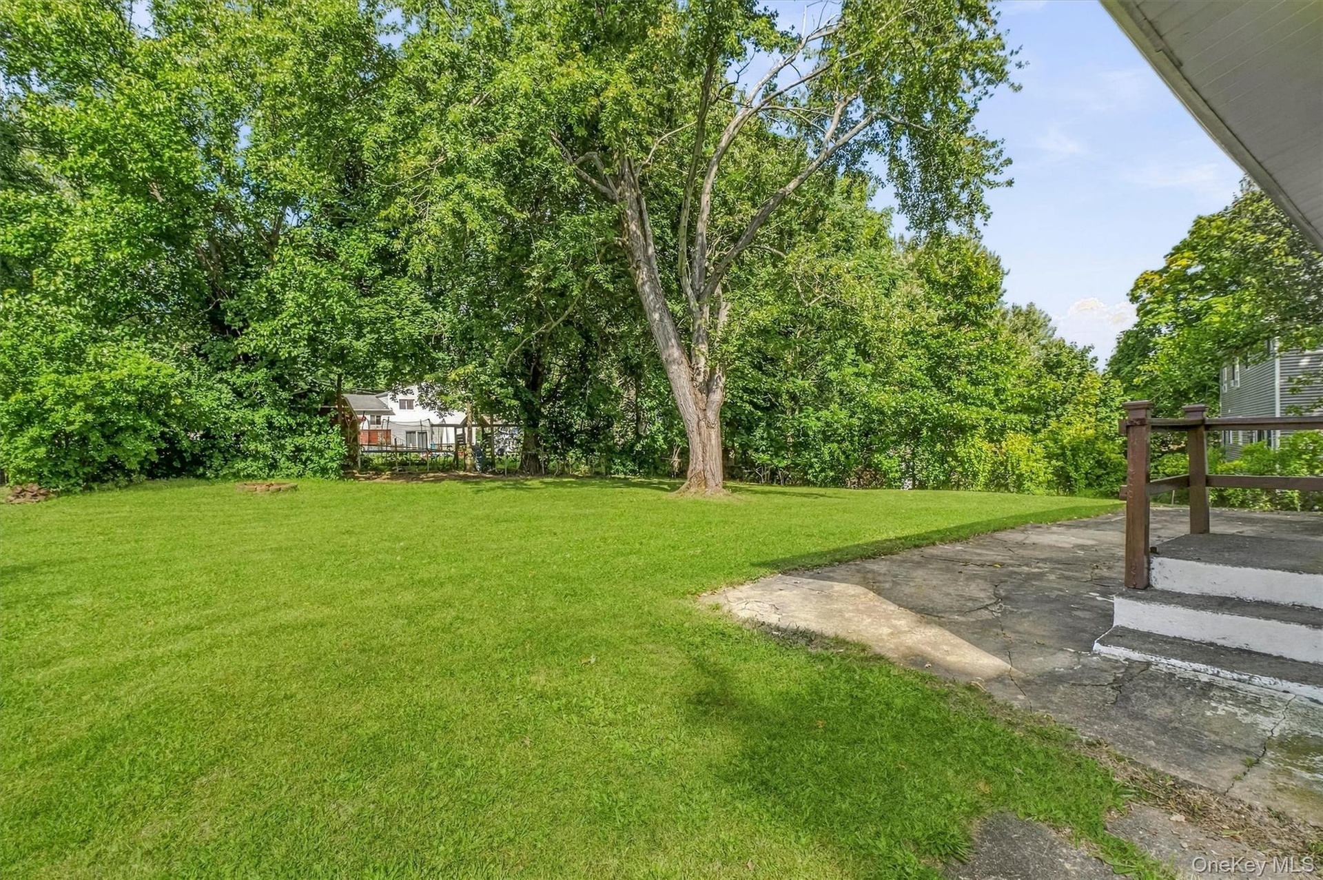 Sprawling yard with mature tress for privacy.