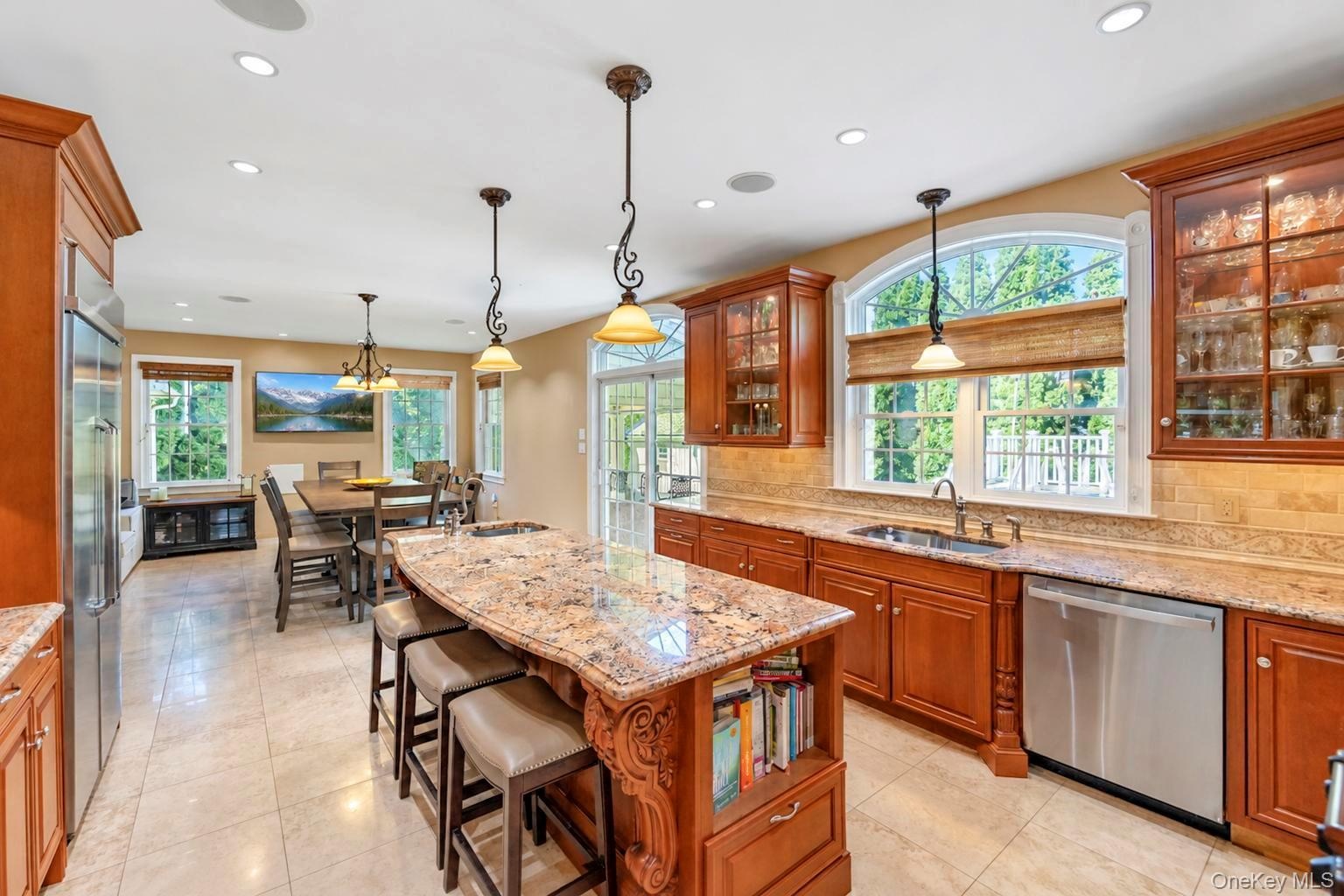 Kitchen featuring a large island with stone countertop, stainless steel appliances, recessed ceiling lights, and arched windows