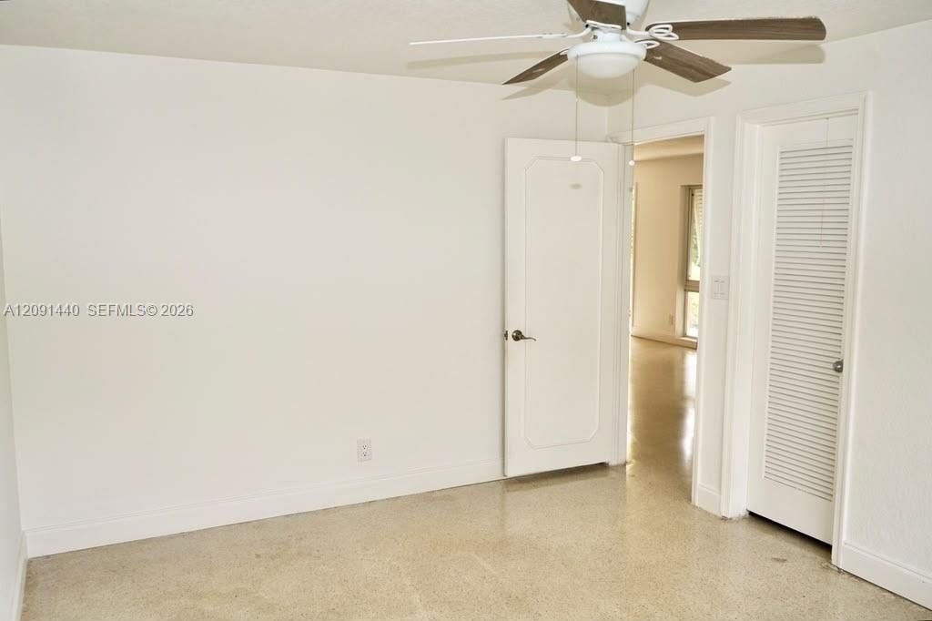 Private backyard featuring a fenced perimeter, grass lawn, mature trees, and large sliding glass doors