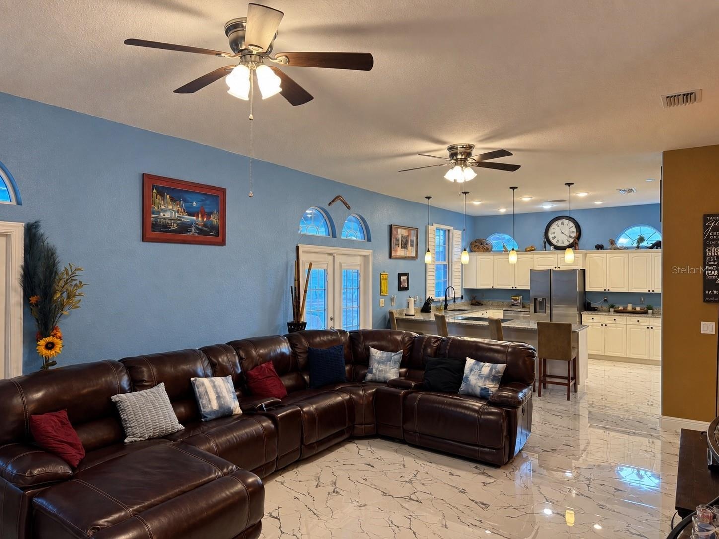 Large living room with view to kitchen and access to backyard through French doors
