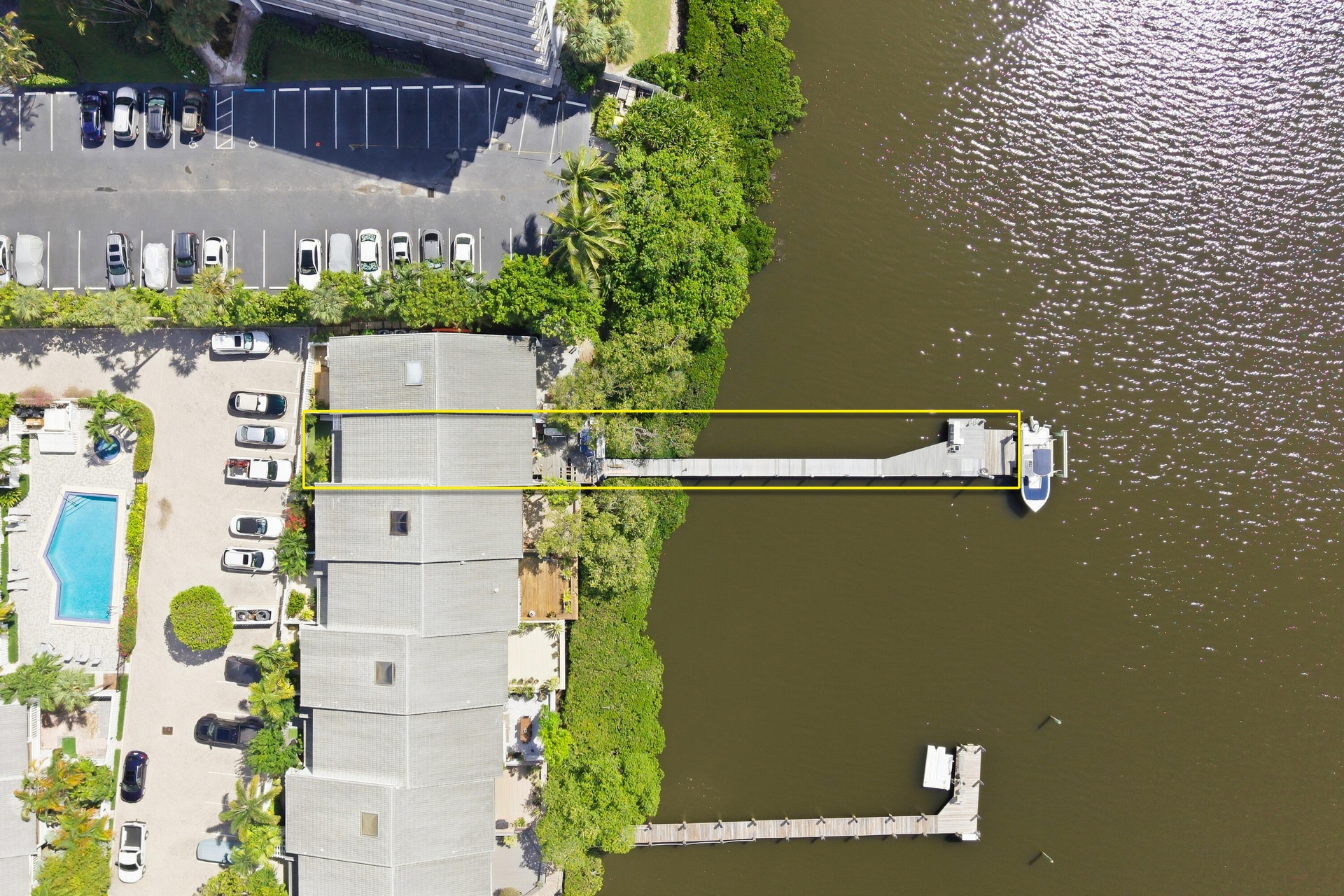 Waterfront property featuring an extensive dock, boat slip, and surrounding lush greenery