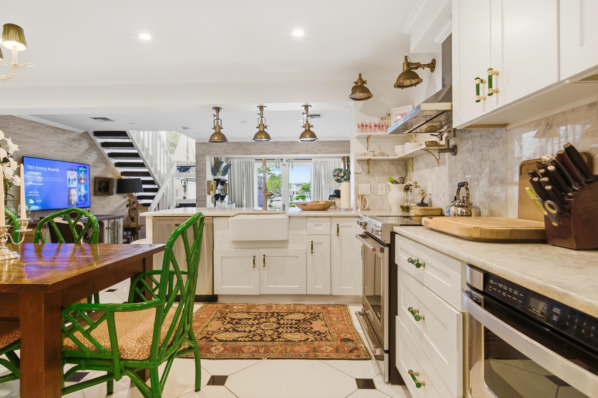 Kitchen featuring white cabinetry, integrated farmhouse sink, stainless steel appliances, and contrasting floor tiles