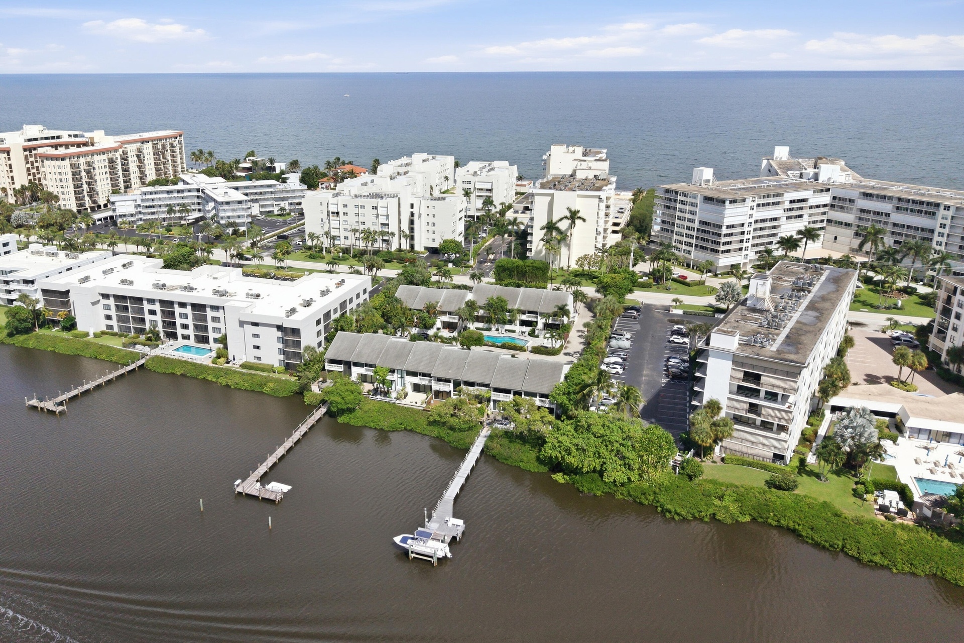 Coastal setting with multiple multi-story residential buildings, private docks, and a swimming pool