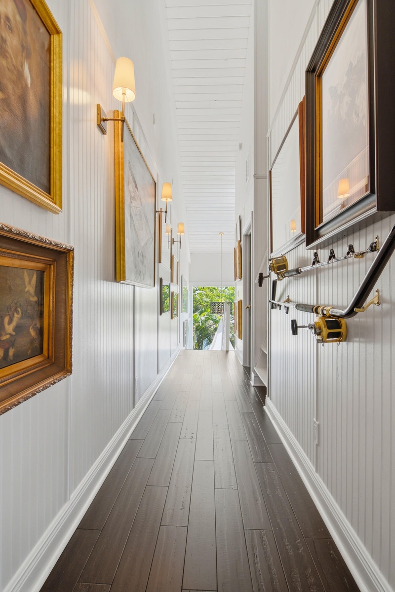 Wood-finish flooring with white baseboards, beadboard wainscoting, and white plank ceiling