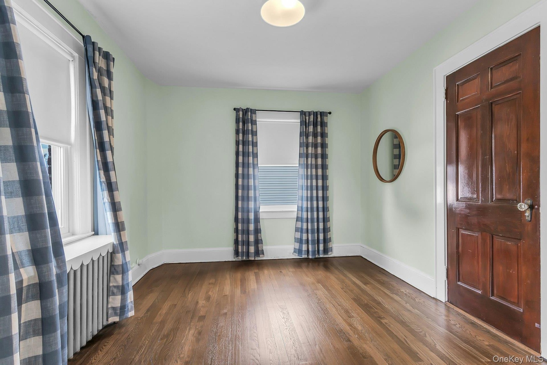 Hardwood flooring, painted walls, white trim, and a paneled wood door