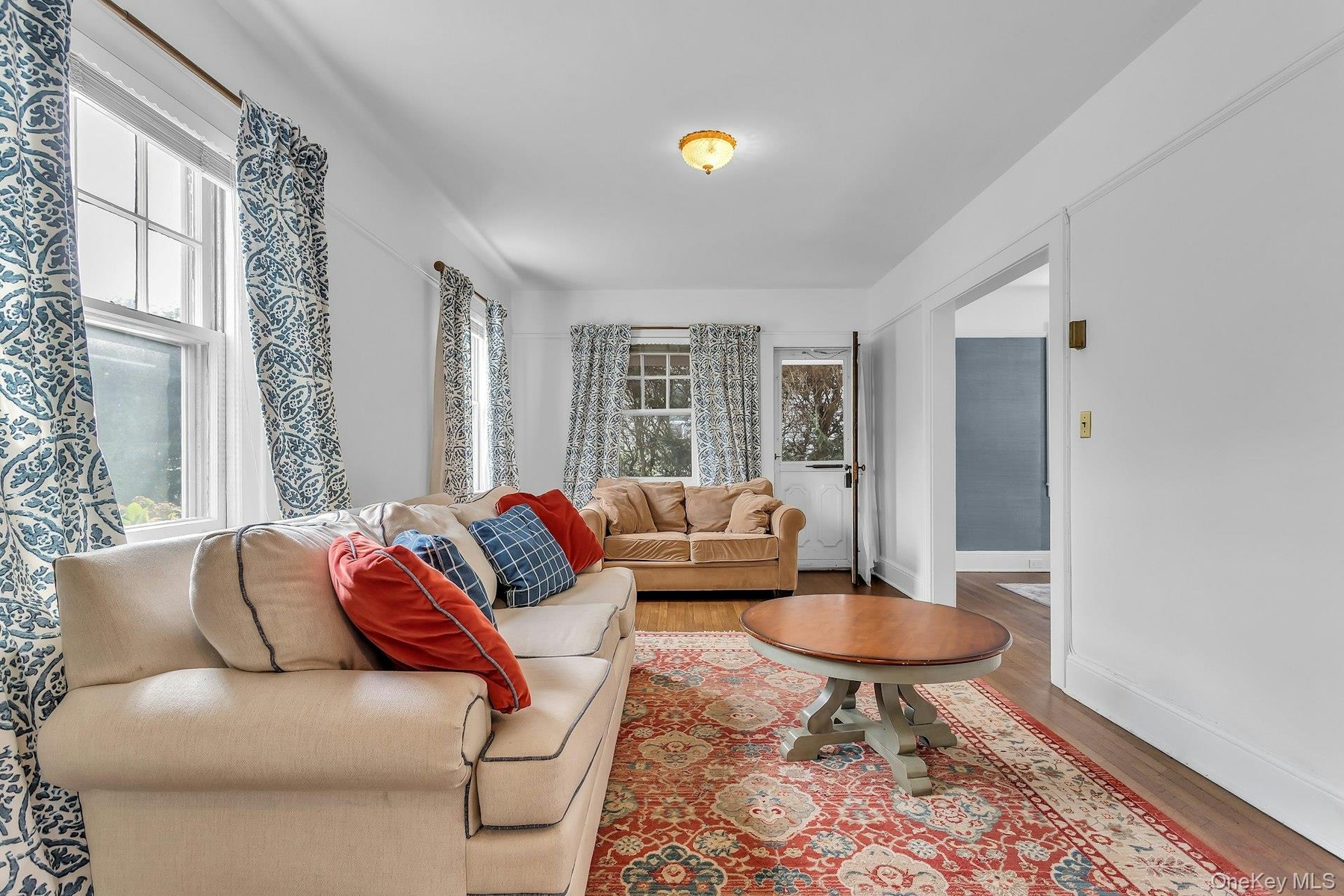Hardwood flooring, painted white walls, recessed doorway, and a ceiling-mounted light fixture