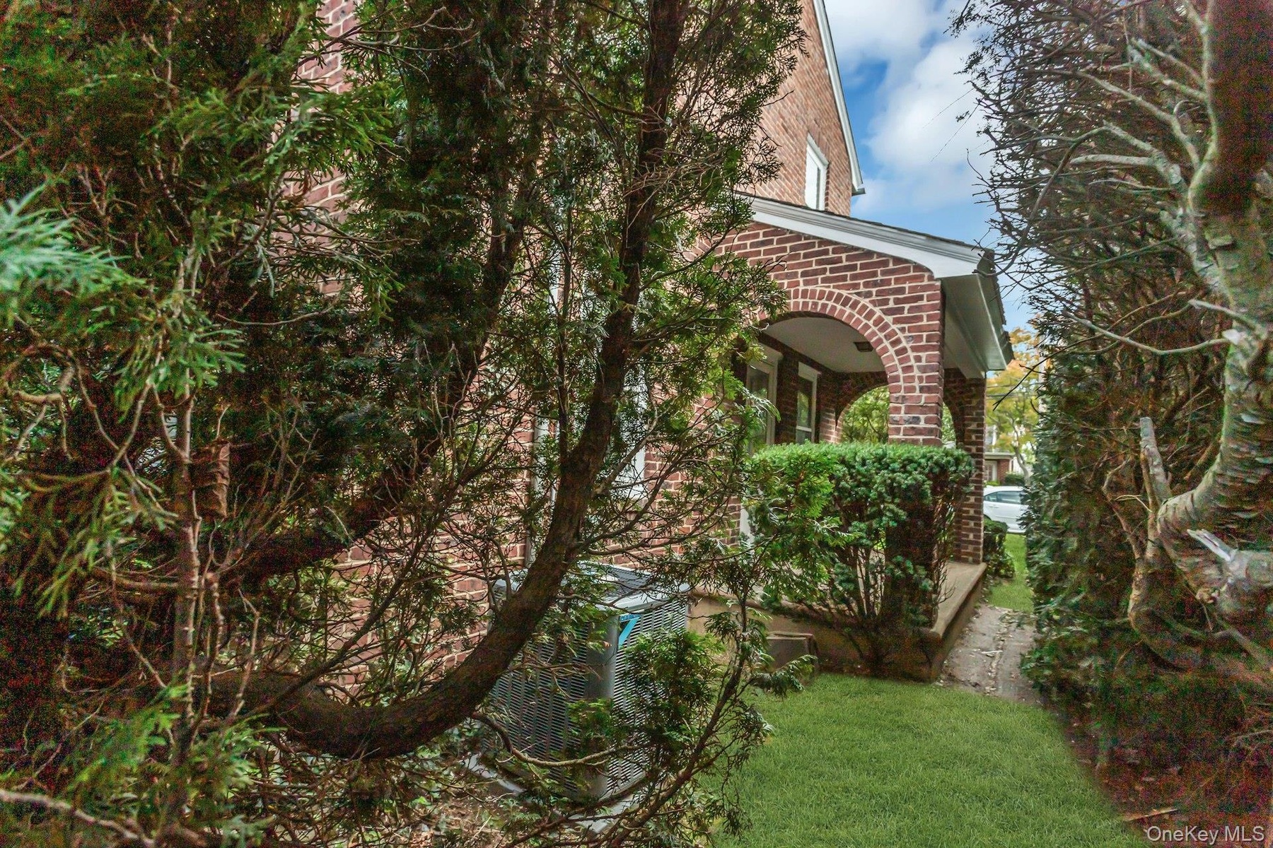Brick facade with a covered entry and arched columns side porch