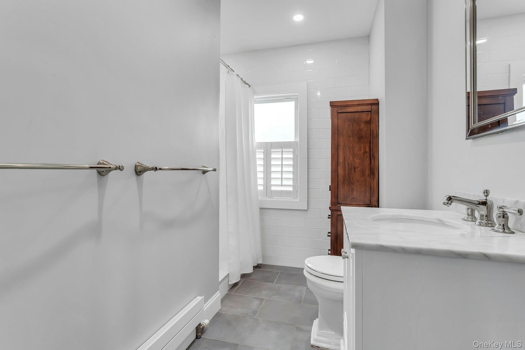 White vanity with a stone countertop and polished chrome fixtures