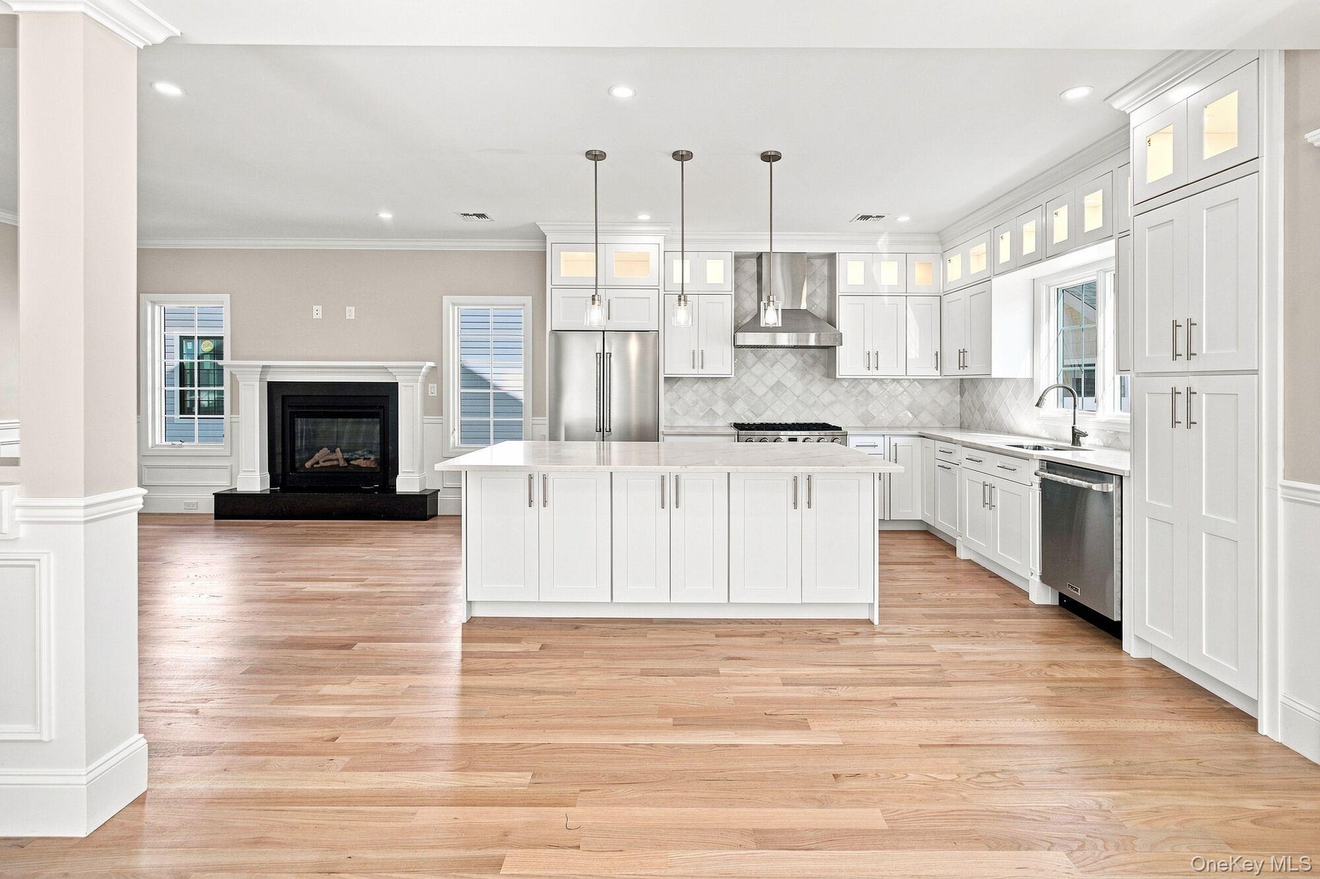 Spacious Kitchen with white shaker cabinetry, stainless steel appliances, and a central island with pendant lighting.