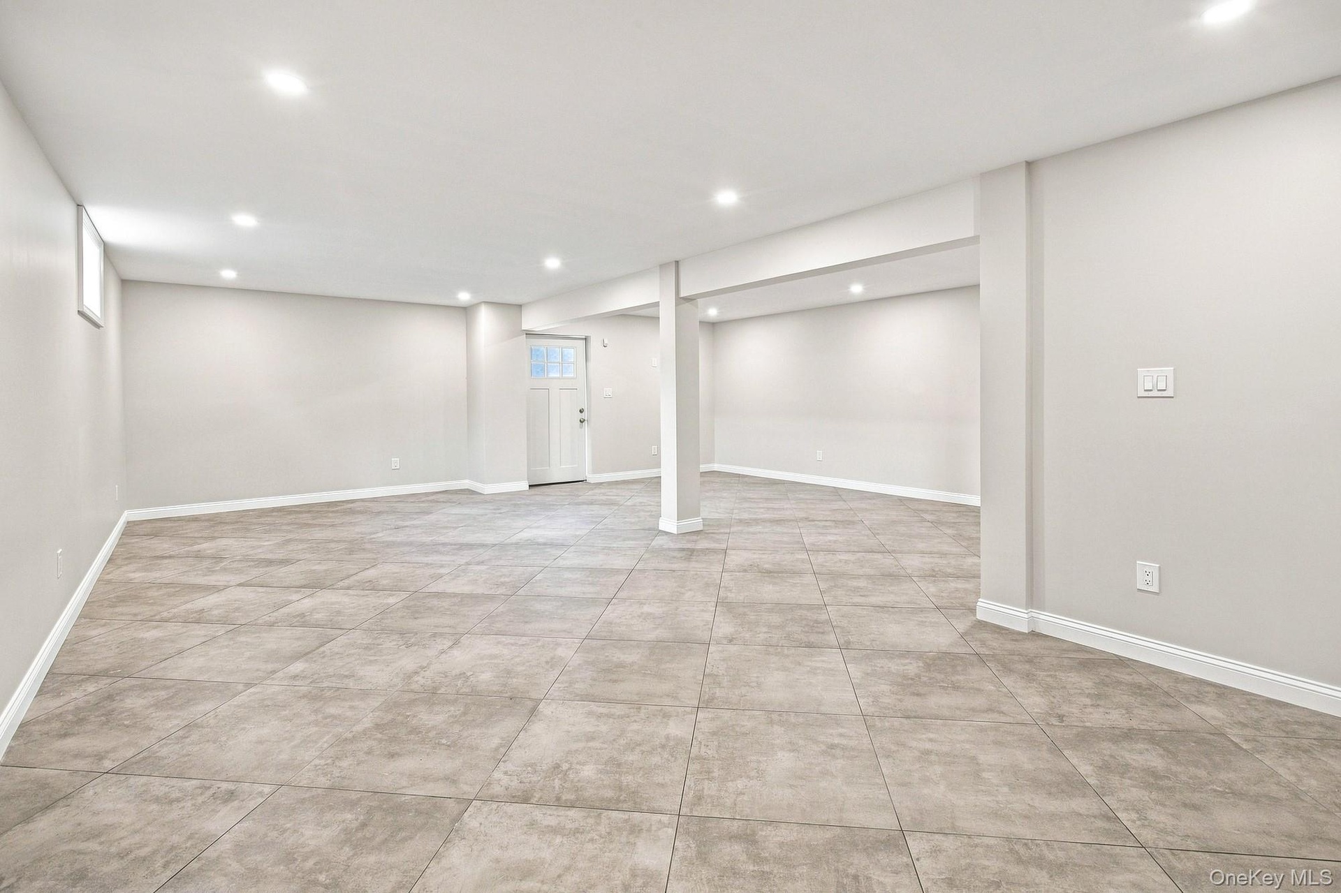 Spacious lower level featuring recessed lighting, light-toned walls, and a ceramic tile flooring.