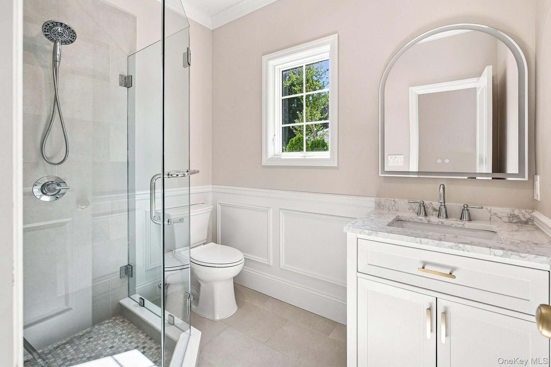 First Floor full bath - glass-enclosed shower with pebble-tile flooring and chrome fixtures