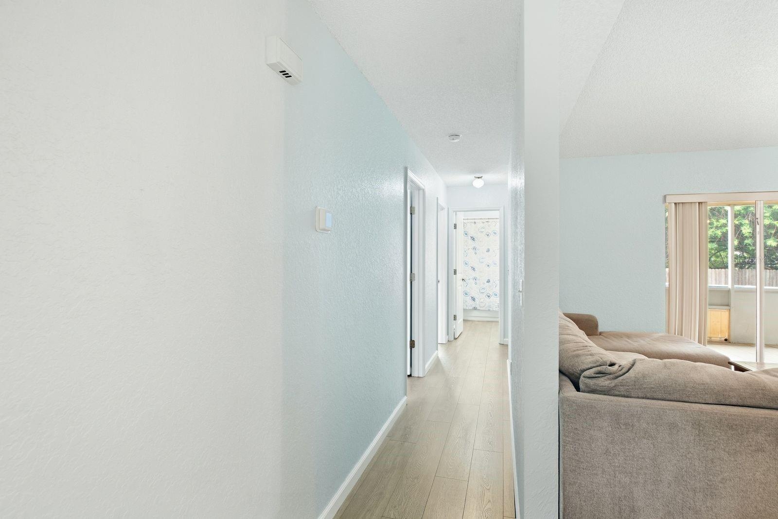Hallway to 2 bedrooms, 1 full bathroom and additional door to back patio and pool area.