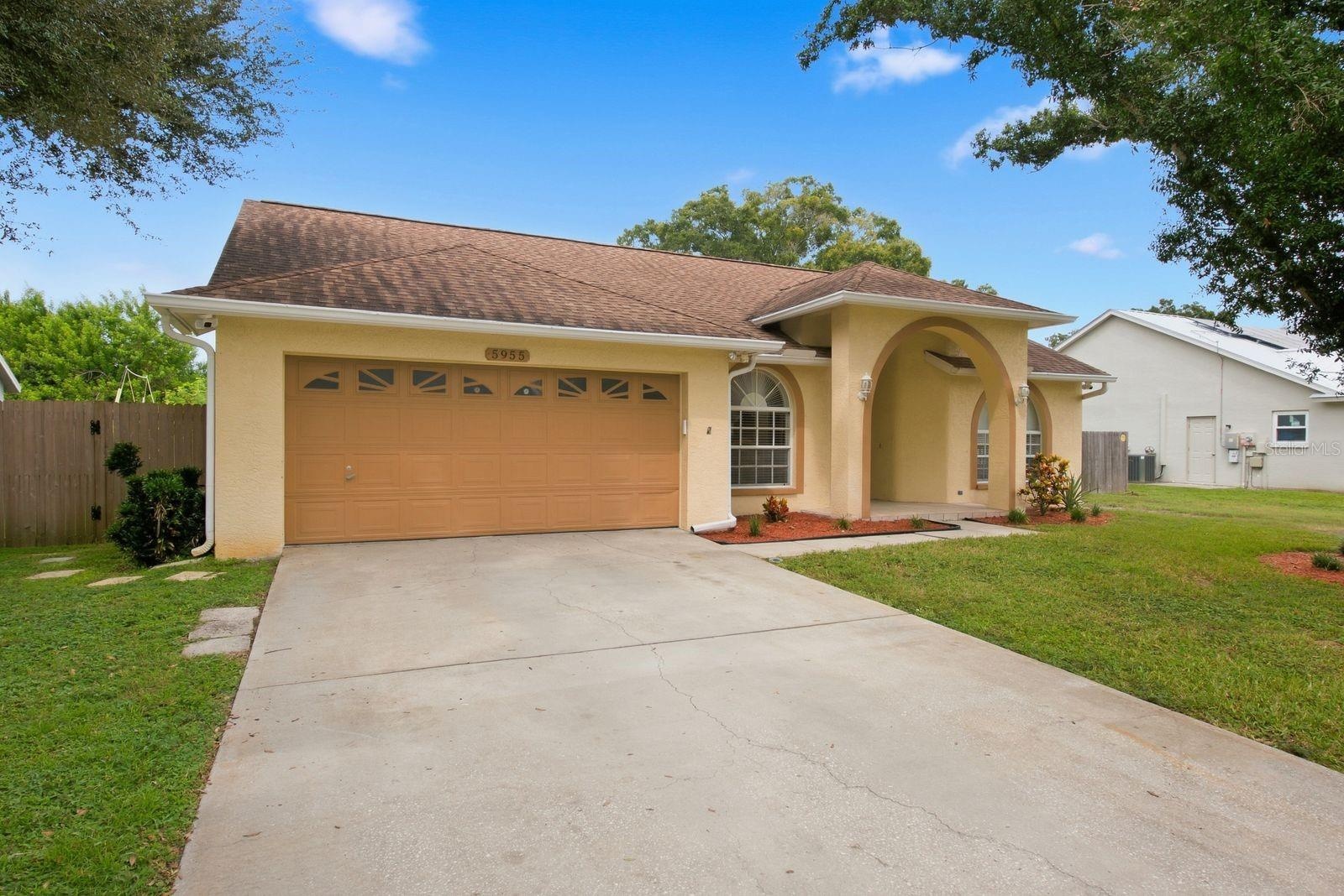 Beautiful curb appeal with a spacious driveway and attached garage.
