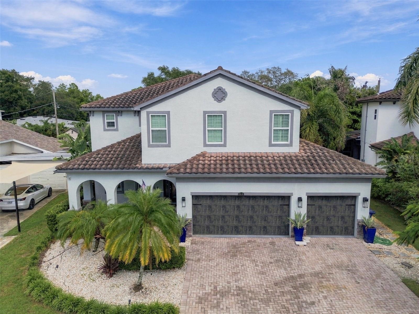 A spacious paver driveway leads to the three car garage