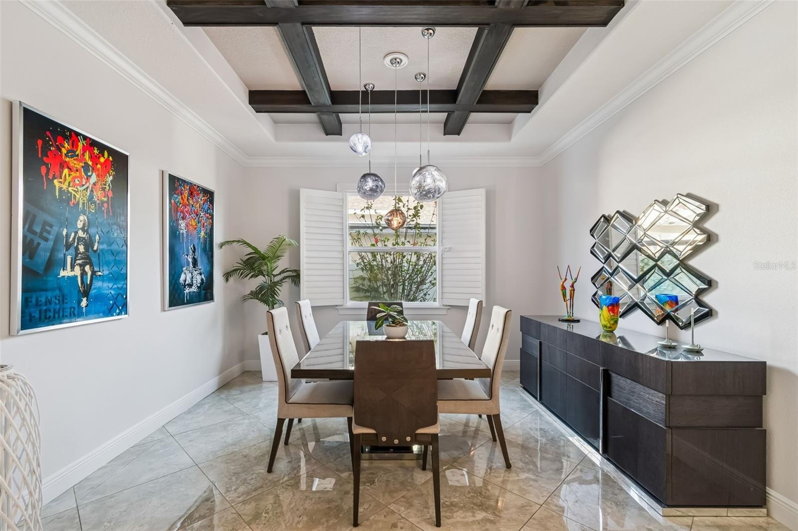 A formal dining room with a coffered ceiling, just beyond the foyer.