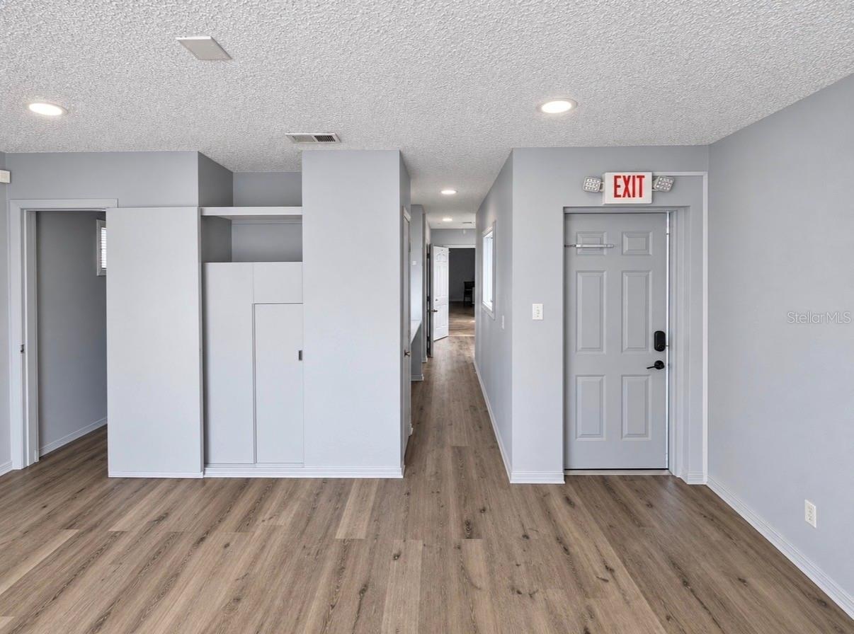 On the left are the entrance door to Office 1, a hallway leading to other offices, and the door to a half-bath.