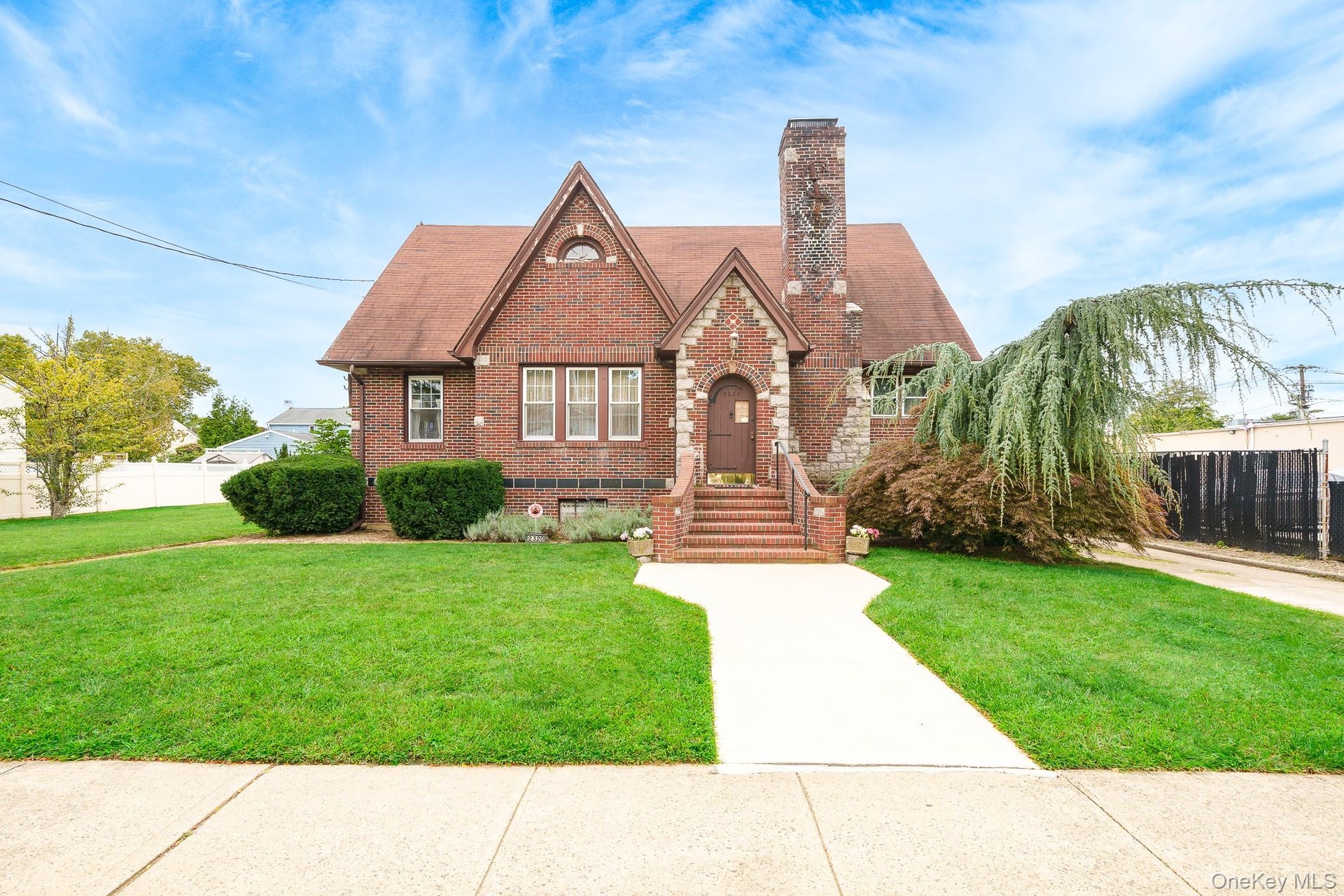 Brick exterior with stone accents, steeply pitched roof, and an arched entry