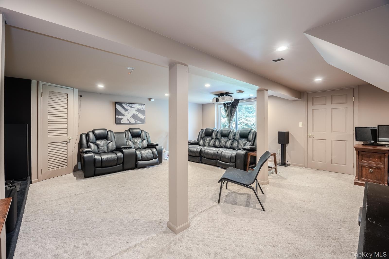 Recessed lighting, light-toned carpeting, and a built-in projector