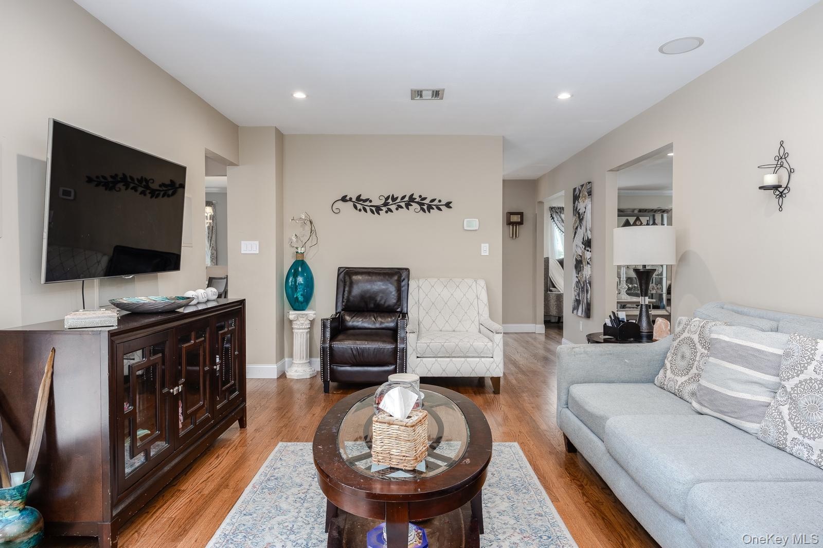 Recessed lighting illuminates wood-finish flooring