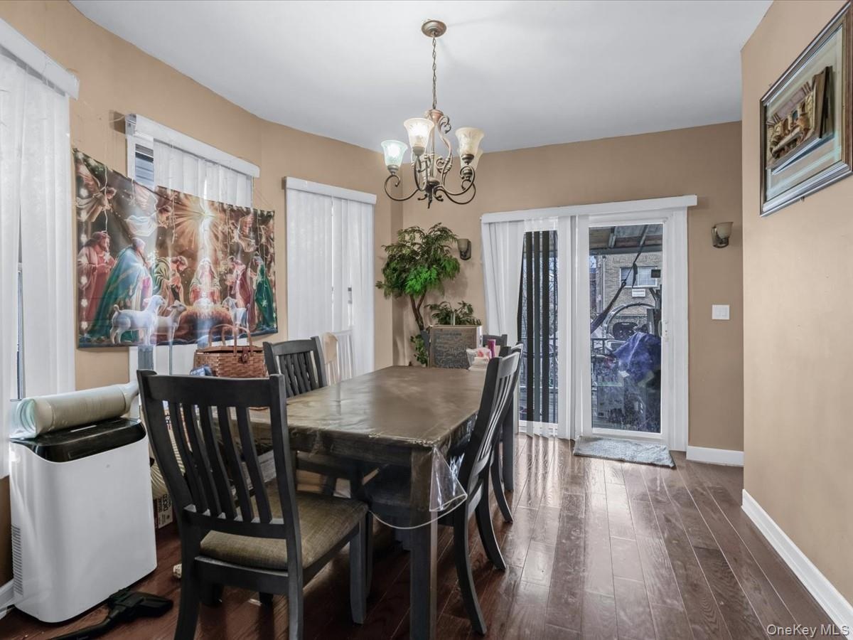 Dining area with dark wood-style floors and a chandelier