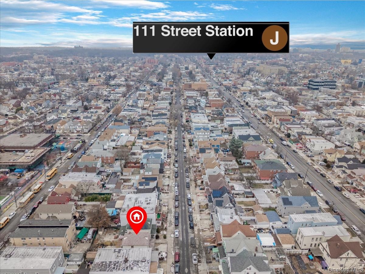 Aerial view of property and surrounding area featuring nearby urban area
