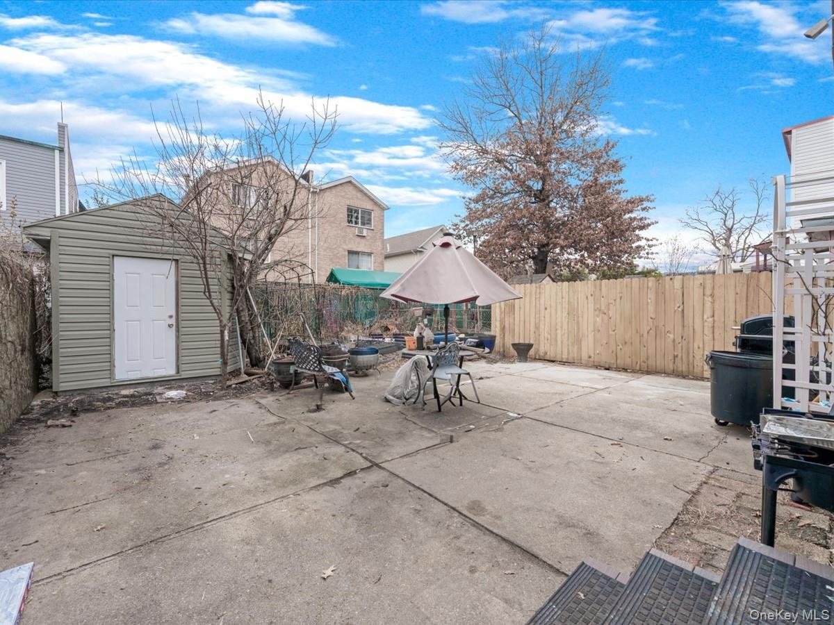 Fenced backyard with a patio, an outdoor fire pit, and a storage shed