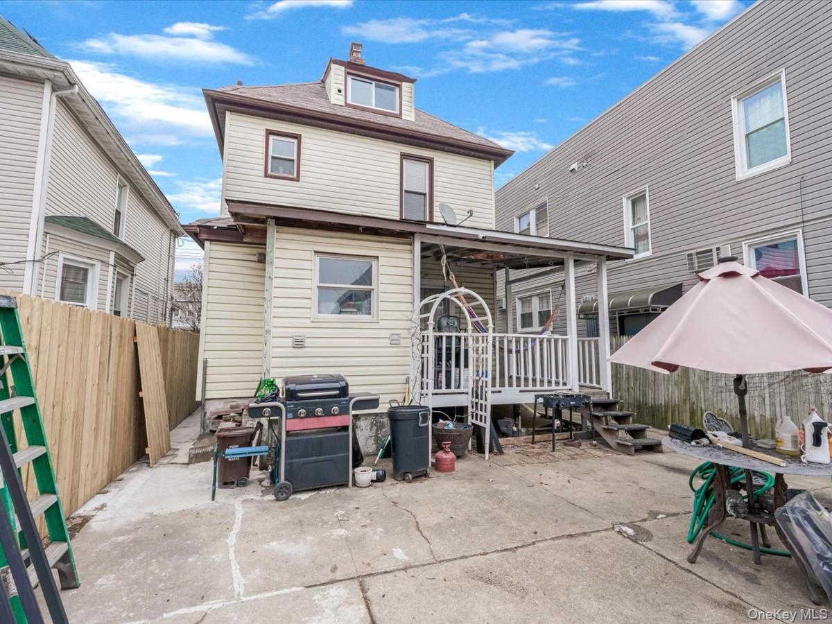 Rear view of house with a patio area and a chimney