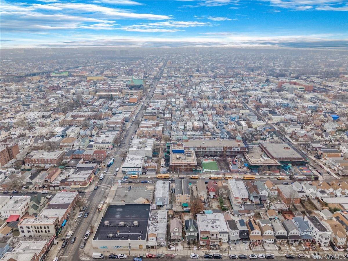 Aerial view of property and surrounding area with nearby urban area
