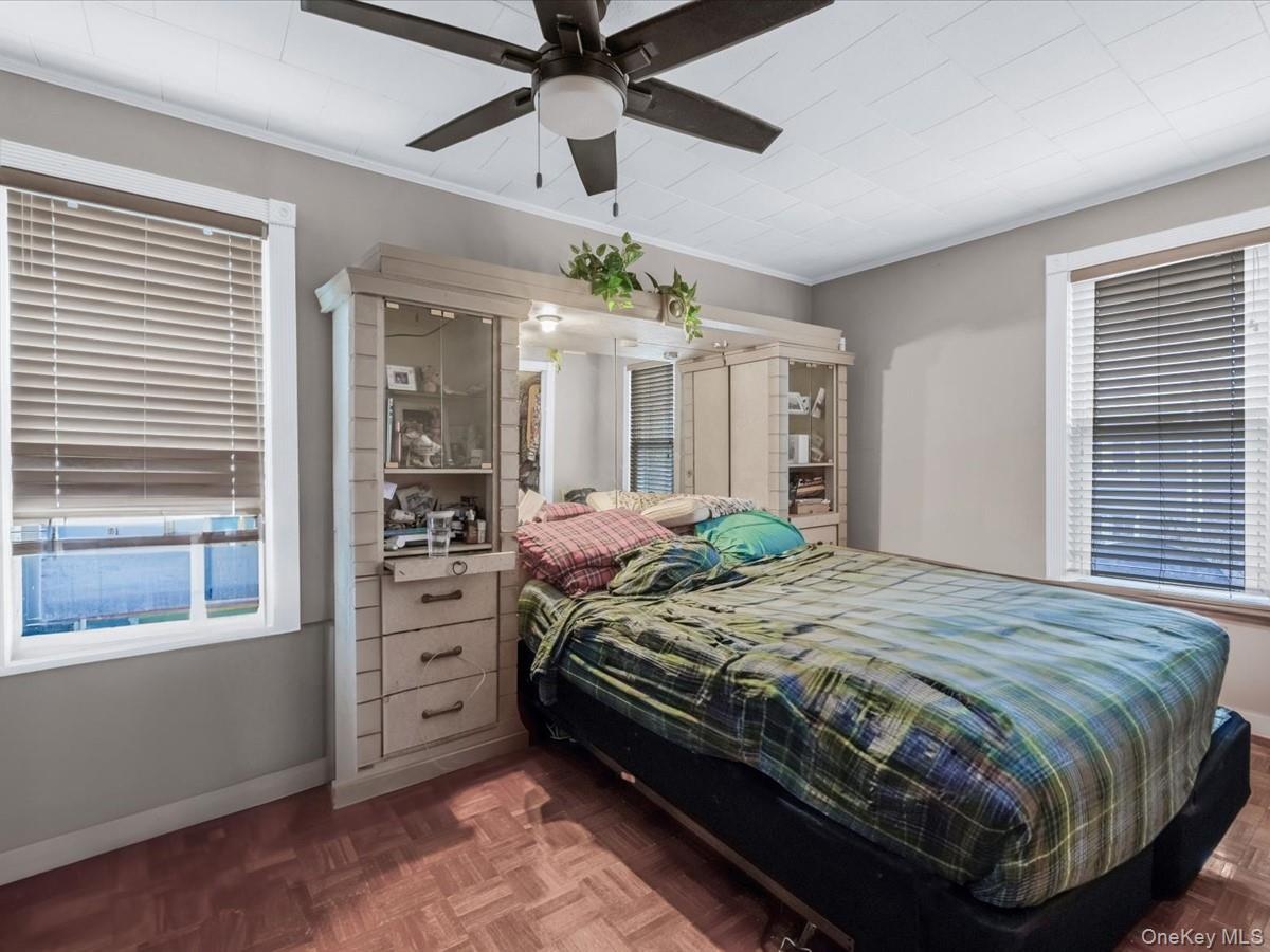 Bedroom with a ceiling fan and ornamental molding