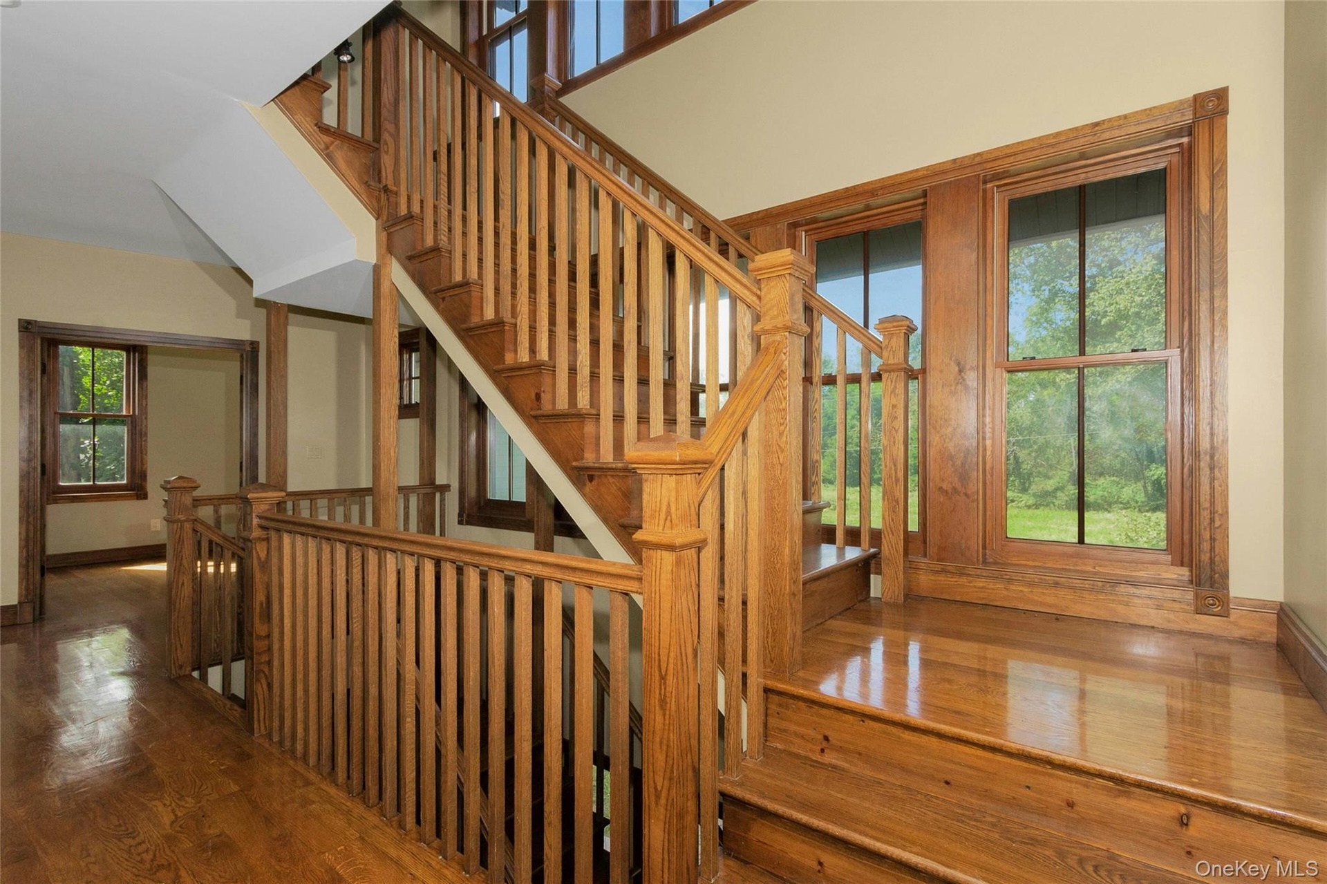 Hardwood flooring and staircase with wood balusters, newel posts, and handrails